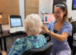 Amazing Hearing audiologist gently examining a patient's ear during a hearing evaluation in Orange County